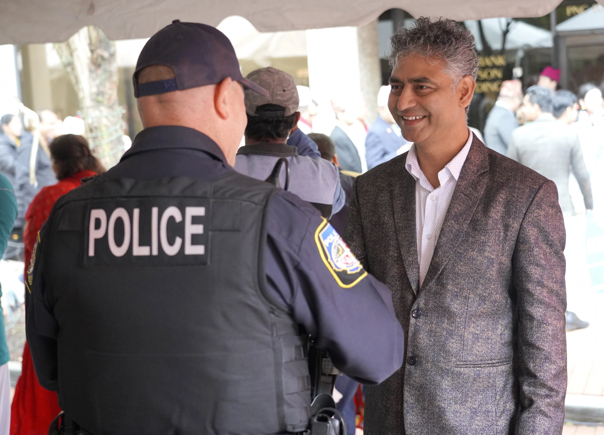 Satish Chapagain shaking hands with a local police officer at a community event